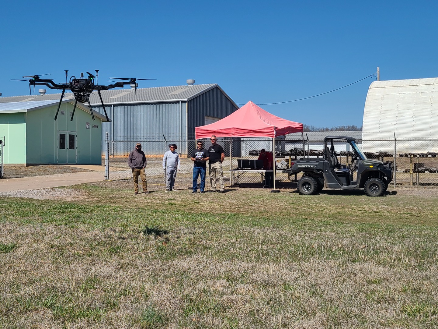 Group of men flying the drone in the foreground