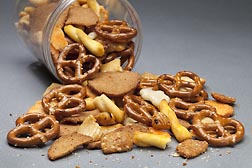 A container of pretzels, crackers and sesame sticks. Link to photo information