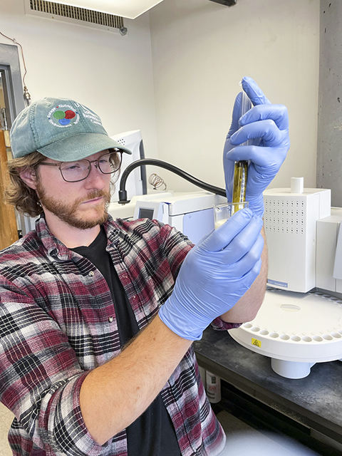 Kevin Panke-Buisse adding indicator dye to a vial containing a sample of milk